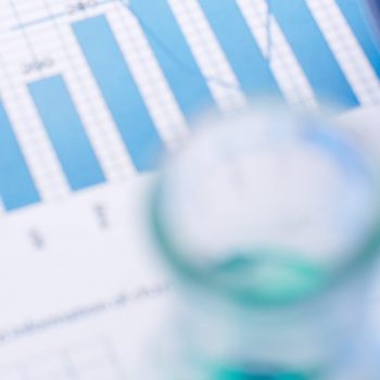 Chemical report Test-tubes with blue liquids over business document